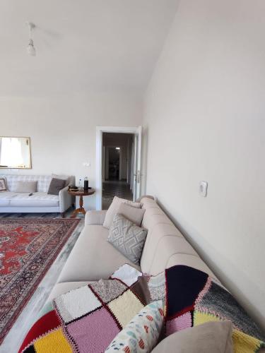 a white living room with a couch and a rug at Adrasan village house in Kumluca