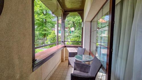 a balcony with a glass table and chairs on it at Jasny Dwór in Polanica-Zdrój