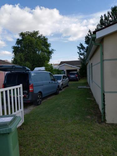 Deux voitures garées dans une cour à côté d'une maison dans l'établissement Eysines 4ch jardin, à Eysines