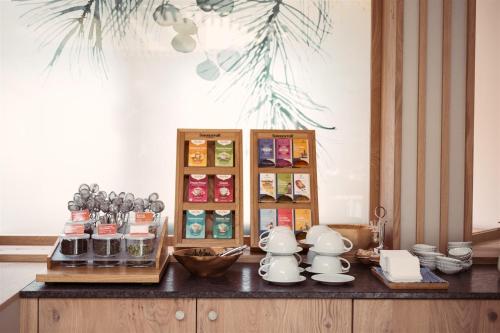 a counter with cups and dishes on top of it at Bergergut Geniesserhotel in Afiesl