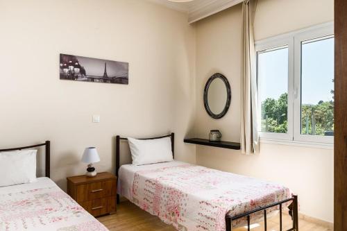 a bedroom with two beds and a window at Villa Anastasia with Private Pool & Outdoor Spa Tub in Agios Ioannis