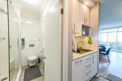 a bathroom with a shower and a toilet and a sink at Unit 151 Brookes Hill Suites in Gqeberha