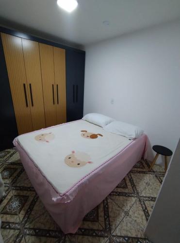 ein Schlafzimmer mit einem Bett mit einer rosa Decke in der Unterkunft Apartamento térreo em palhoça in Palhoça