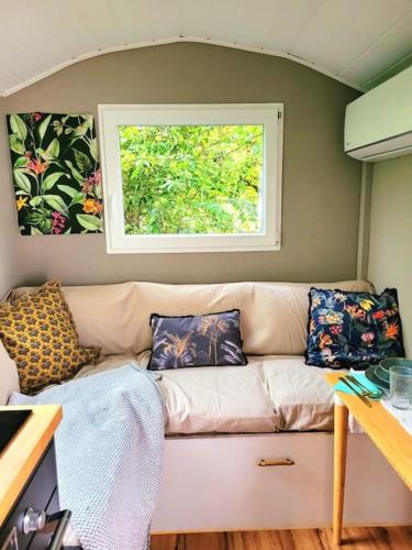 a living room with a couch and a window at Tiny Bungalow in Oberdiessbach in Oberdiessbach