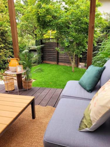 a patio with a couch and a yard with grass at Tiny Bungalow in Oberdiessbach in Oberdiessbach