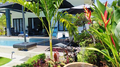 a villa with a swimming pool and some plants at Villa Beau Rivage in Bachok