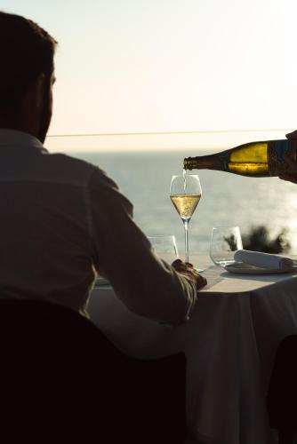 a person sitting at a table with a glass of wine at 7Pines Resort Ibiza, part of Destination by Hyatt in San Jose