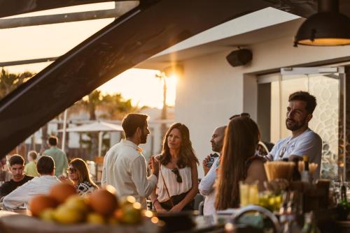 a group of people standing outside a restaurant at 7Pines Resort Ibiza, part of Destination by Hyatt in San Jose