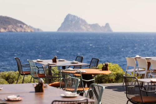 a row of tables and chairs with a view of the ocean at 7Pines Resort Ibiza, part of Destination by Hyatt in San Jose