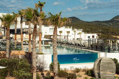 a hotel with a swimming pool with palm trees at 7Pines Resort Ibiza, part of Destination by Hyatt in San Jose