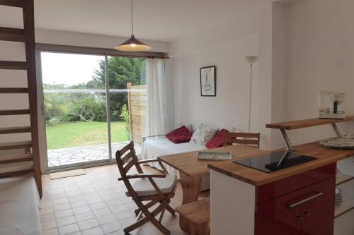 une cuisine et un salon avec une table et un canapé dans l'établissement REF 015 Golfe du Morbihan - Kerners -Maison mitoyenne 3 couchages, à Arzon