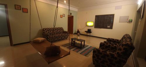 a living room with two chairs and a table at SHI's Triveni Spacious 2BHK Villa in Pappampatti, Coimbatore in Coimbatore