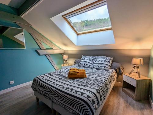 a bedroom with a large bed with a skylight at Maison Gite Le Bressaud in La Bresse