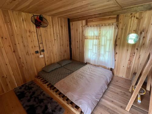 Piccola camera con letto in una baita di tronchi. di Field House SaPa - Nậm Cang a Lao Cai