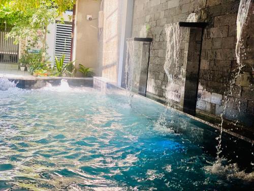 a swimming pool with a water fall at Cleopatra homestay &villa in Thôn Dương Xuân Hạ