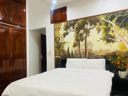 a bedroom with a bed with a painting on the wall at Cleopatra homestay &villa in Thôn Dương Xuân Hạ