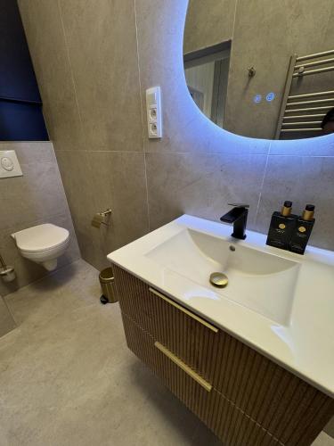 a bathroom with a white sink and a mirror at Luxury Suits Royal by Rikas Hotels in Antwerp