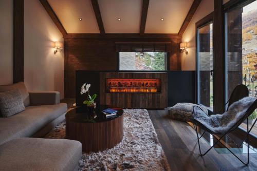 a living room with a couch and a fireplace at SCHLOSS Zermatt - CBD & Adaptogenic Spa and Sport Hotel in Zermatt
