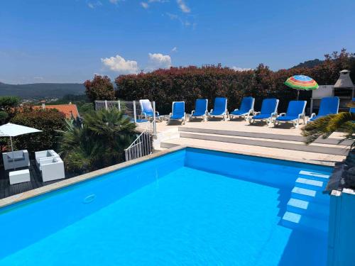 a swimming pool with blue chairs at Casa da Lapa in Aspra