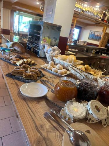 a buffet line with different types of bread and pastries at Ski Lodge Pampeago in Tesero