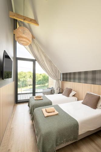 a bedroom with three beds and a large window at Campo Resort in Duszniki Zdrój