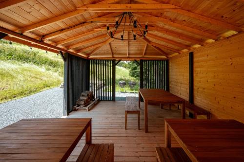 a wooden porch with benches and a chandelier at Campo Resort in Duszniki Zdrój