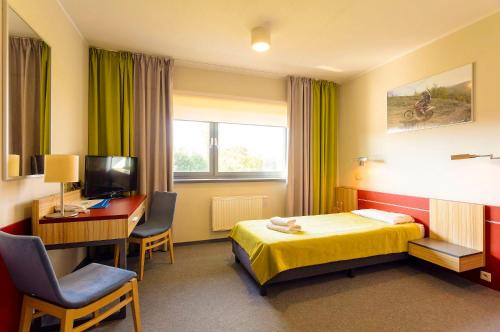 a hotel room with a bed and a desk and a computer at Aqua-Zdrój in Wałbrzych