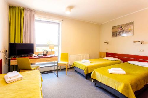 a hotel room with two beds and a desk at Aqua-Zdrój in Wałbrzych