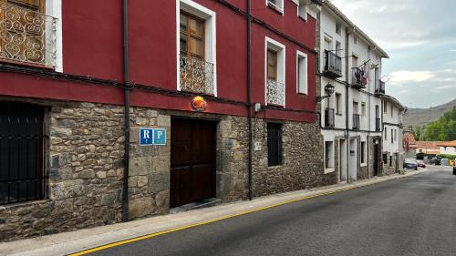 a red and white building on the side of a street at Hotel - Restaurante La Posada de Santa Rita in Enciso