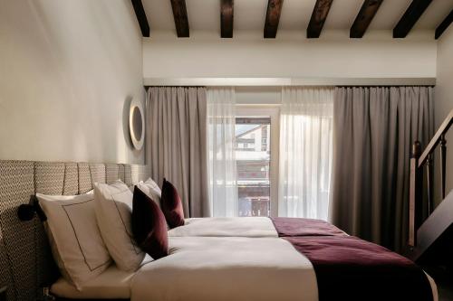 a bedroom with a large bed and a window at SCHLOSS Zermatt - CBD & Adaptogenic Spa and Sport Hotel in Zermatt