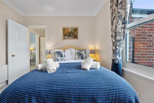 a bedroom with a blue and white bed with pillows at 2-Bedroom Stunning, Chic, Spacious & Stylish Retreat, Central Winchester, Free On-Street Parking, Sleeps 6, Pet-Friendly - by Blue Puffin Stays in Winchester