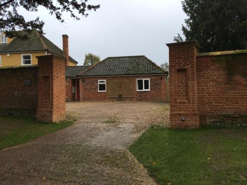 an old brick house with a driveway in front of it at Beautifully appointed & cosy self contained annexe in Walsham le Willows