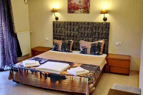 a hotel room with a bed with towels on it at Хотел Свети Трифон in Melnik