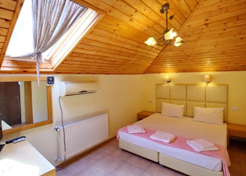 a bedroom with a bed in a wooden ceiling at Хотел Свети Трифон in Melnik
