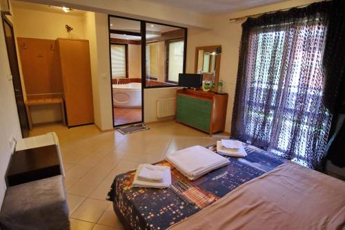 a bedroom with a bed with towels on it at Хотел Свети Трифон in Melnik