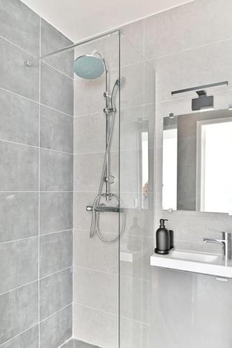 une douche avec une porte vitrée dans une salle de bain dans l'établissement Studio confortable - Havre de Paix proche Paris, à Montreuil