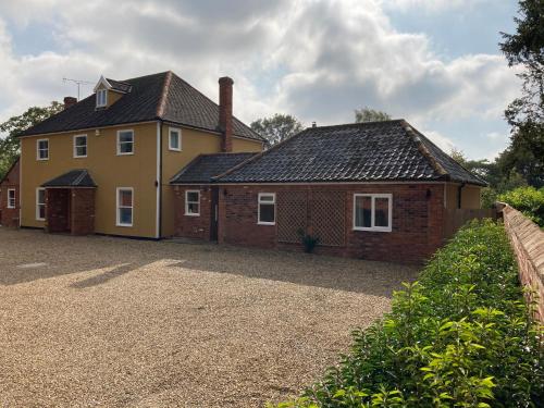 a large yellow house with a brick at Beautifully appointed & cosy self contained annexe in Walsham le Willows