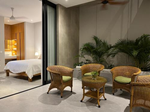 a bedroom with a bed and chairs and a table at Brand New! Private Room near Canggu Surfing Beaches in Canggu