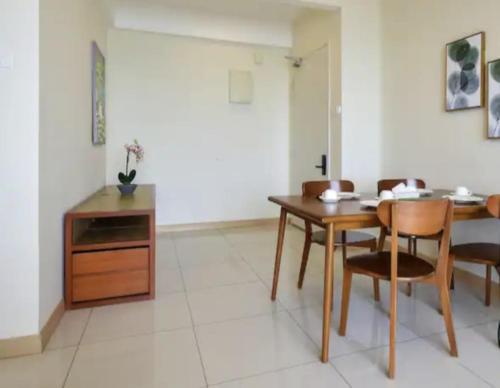 a dining room with a wooden table and chairs at Timurbay Seafront Residence & Suites in Kuantan