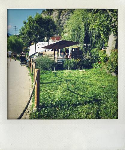 a park with a table and an umbrella on the grass at casa mileti in Vercurago