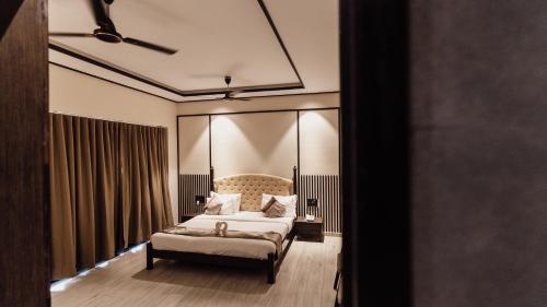 a bedroom with a bed and a large window at THE PREMIER GIR RESORT in Sasan Gir