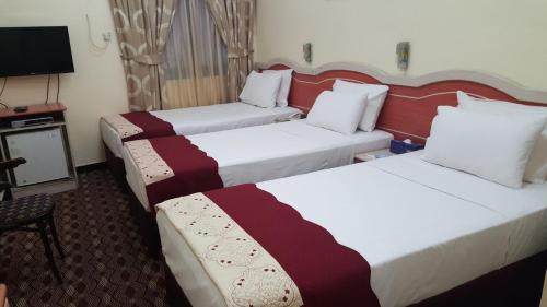 a hotel room with two beds and a television at Al Ahrar Hotel in Dubai