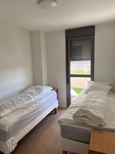 two beds in a room with a window at Casa Verde Dénia in Denia