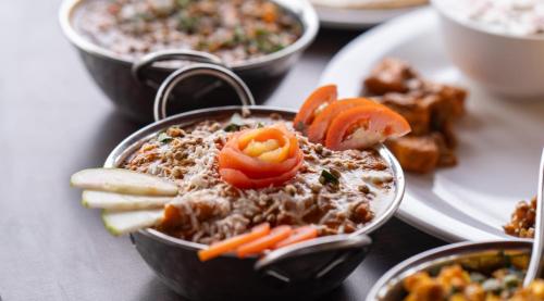 a bowl of food with tomatoes and other foods on a table at THE PREMIER GIR RESORT in Sasan Gir