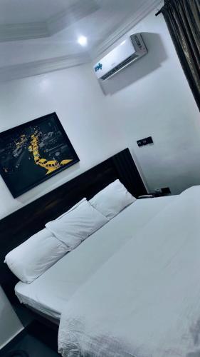 a bedroom with a bed with white pillows at Skenyo Hotel & Apartments in Ketti