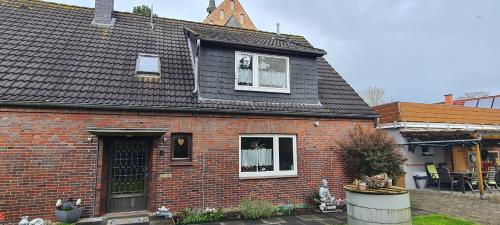a red brick house with a black roof at Lichtblick in Wangerland