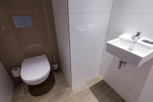 a bathroom with a white toilet and a sink at Van der Valk Hotel Haarlem in Haarlem