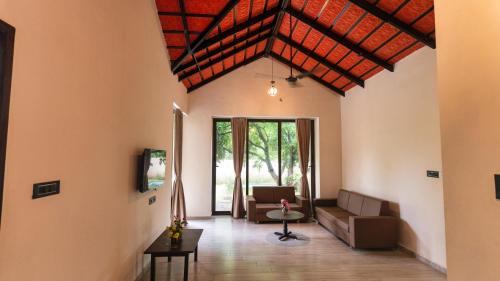 a living room with a couch and a table at THE PREMIER GIR RESORT in Sasan Gir