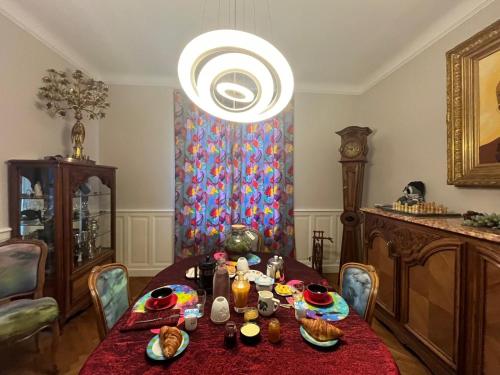 une salle à manger avec une table et un lustre dans l'établissement HYPER CENTRE ,jolie chambre climatisée avec PARKING SECURISE gratuit, à Clermont-Ferrand