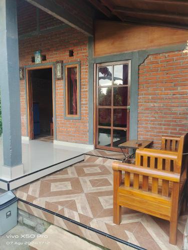 a patio with a bench and a brick wall at Pondok Pengaringan Loon in Gitgit